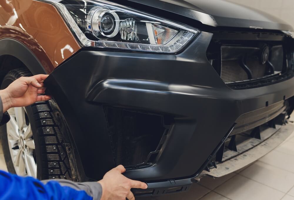 Black car bumper inspection for auto bumper repair